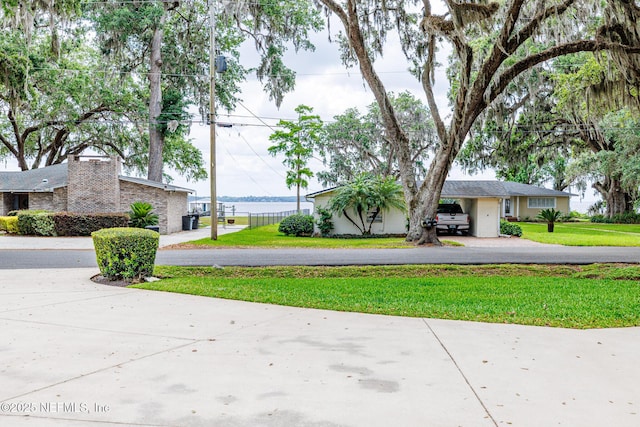 exterior space featuring fence, a front yard, and aphalt driveway