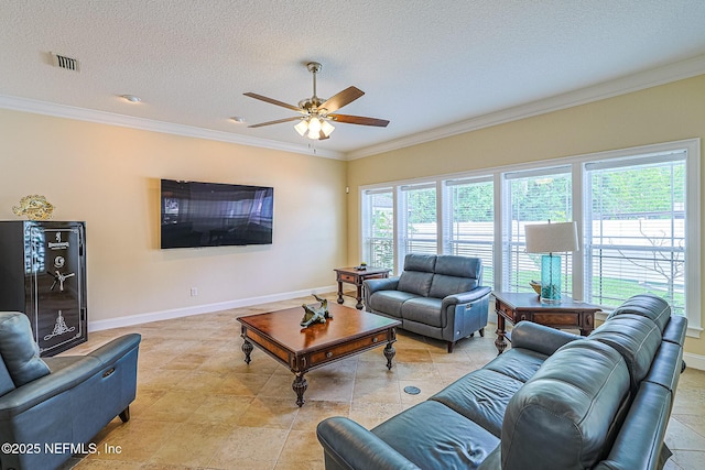 living room featuring ceiling fan, a textured ceiling, visible vents, baseboards, and ornamental molding