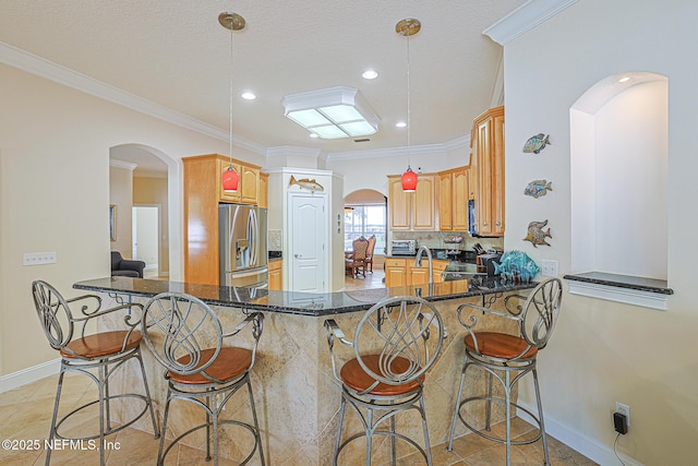 kitchen with stainless steel fridge with ice dispenser, baseboards, and arched walkways