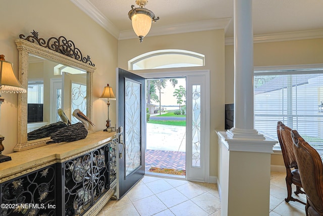 entryway with ornamental molding, decorative columns, light tile patterned flooring, and a wealth of natural light