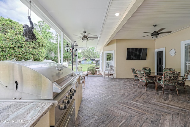 view of patio / terrace featuring ceiling fan, a wooden deck, outdoor dining area, and a grill