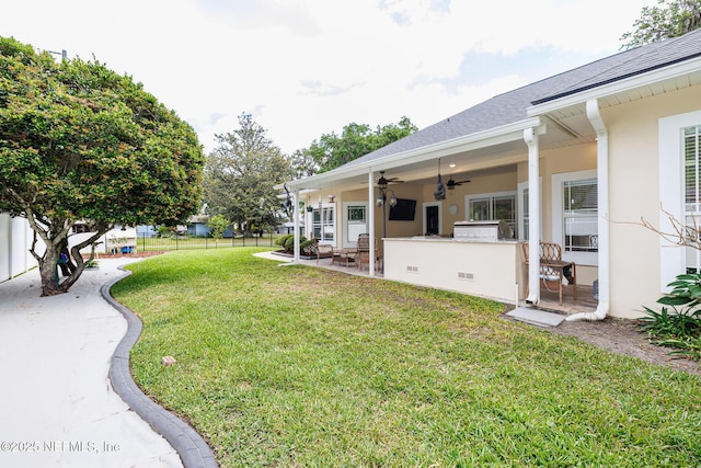 view of yard with area for grilling, a ceiling fan, visible vents, fence, and a patio