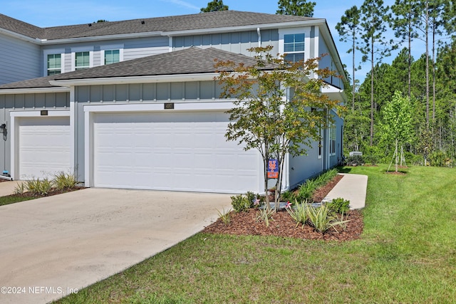 497 Coastline Way, Saint Augustine, FL 32092 - view of front of house featuring board and batten siding, a shingled roof, driveway, a front yard, and an attached garage