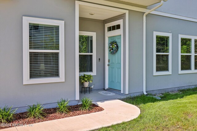 497 Coastline Way, Saint Augustine, FL 32092 - view of exterior entry featuring stucco siding and a yard