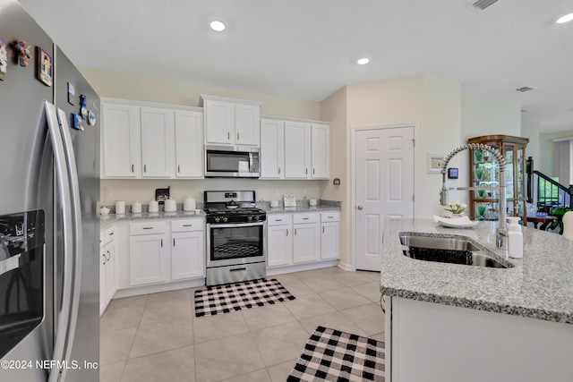 497 Coastline Way, Saint Augustine, FL 32092 - kitchen with appliances with stainless steel finishes, a sink, white cabinets, light tile patterned floors, and light stone counters