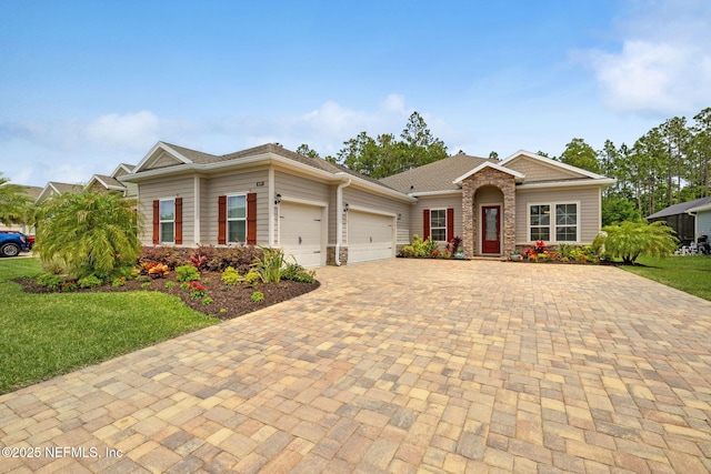 149 San Telmo Ct, Saint Augustine, FL 32095 - view of front of home featuring stone siding, a garage, a front lawn, and decorative driveway