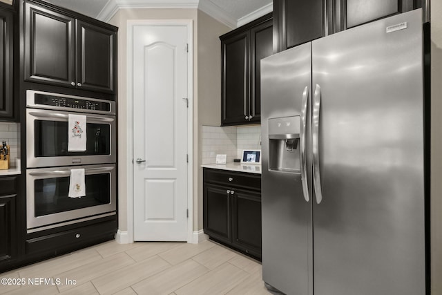 149 San Telmo Ct, Saint Augustine, FL 32095 - kitchen featuring crown molding, appliances with stainless steel finishes, tasteful backsplash, and dark cabinetry