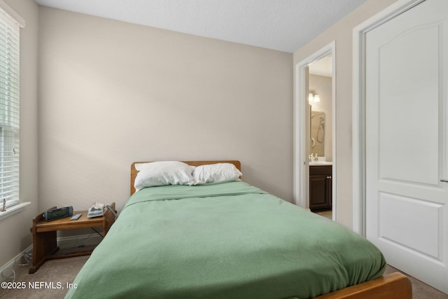 149 San Telmo Ct, Saint Augustine, FL 32095 - bedroom featuring baseboards, ensuite bathroom, a sink, and carpet