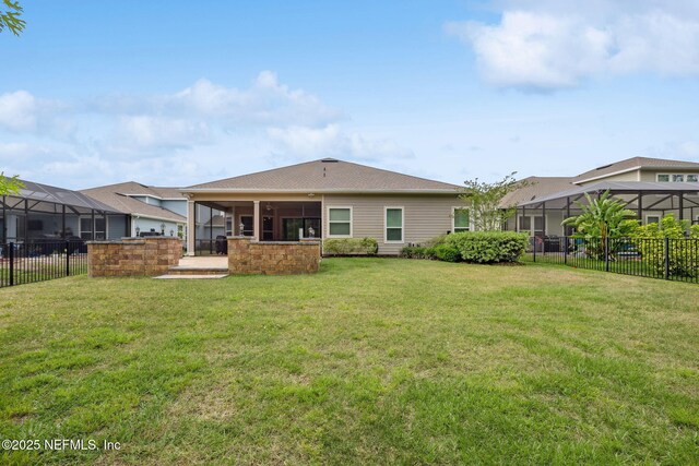 149 San Telmo Ct, Saint Augustine, FL 32095 - back of house with a fenced backyard, a sunroom, and a lawn
