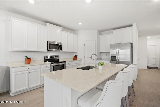 115 Beauclair Blvd, Saint Augustine, FL 32084 - kitchen featuring white cabinetry, appliances with stainless steel finishes, a sink, and light wood-type flooring