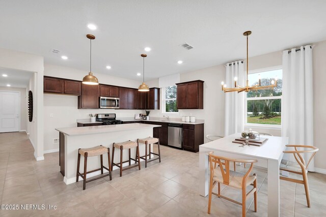 950 Rooster Hallow Way, Middleburg, FL 32068 - kitchen with visible vents, appliances with stainless steel finishes, a center island, dark brown cabinets, and a sink