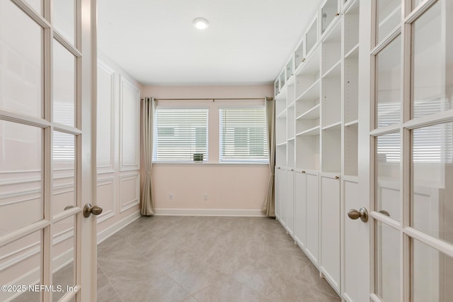 empty room featuring light tile patterned flooring and baseboards