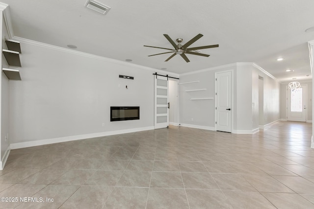 unfurnished living room featuring ceiling fan, visible vents, crown molding, a barn door, and light tile patterned floors