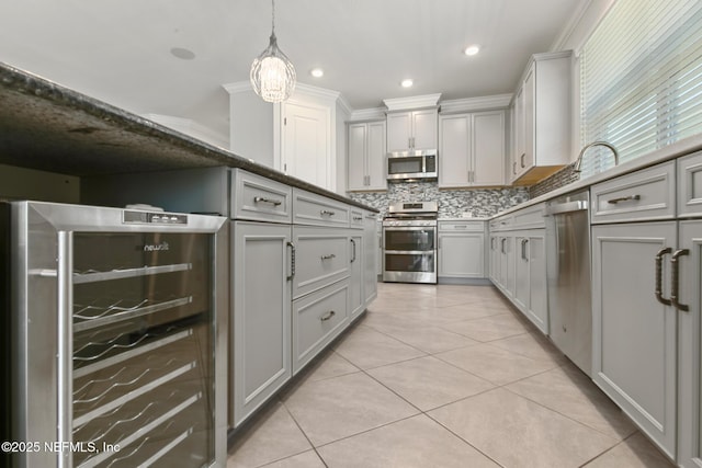 kitchen featuring appliances with stainless steel finishes, gray cabinets, decorative backsplash, and beverage cooler