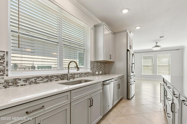kitchen with a sink, light tile patterned floors, tasteful backsplash, and stainless steel appliances