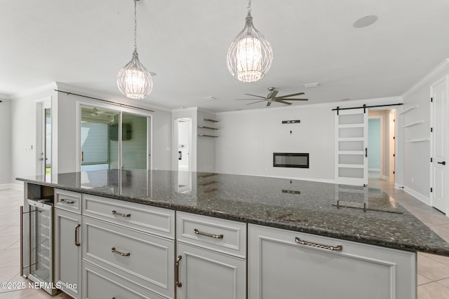kitchen with wine cooler, light tile patterned floors, ornamental molding, and ceiling fan with notable chandelier