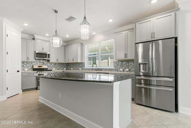 kitchen with visible vents, a center island, tasteful backsplash, appliances with stainless steel finishes, and light tile patterned floors