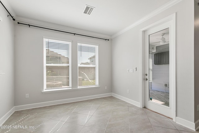 spare room featuring crown molding, baseboards, and visible vents