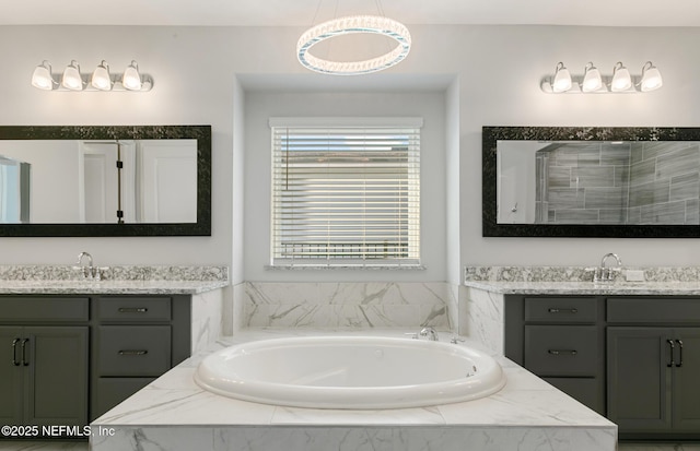 bathroom featuring a sink, a bath, and two vanities