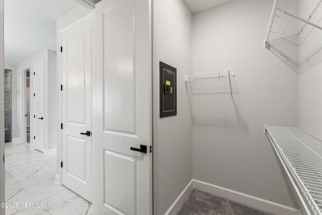 walk in closet featuring marble finish floor