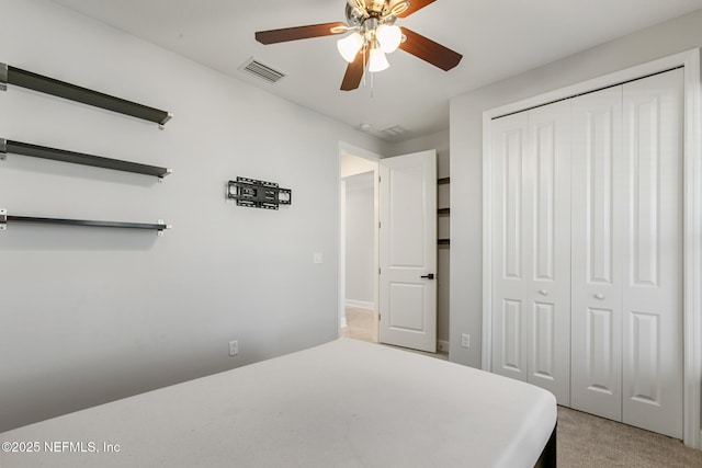 bedroom with a ceiling fan, a closet, light colored carpet, and visible vents