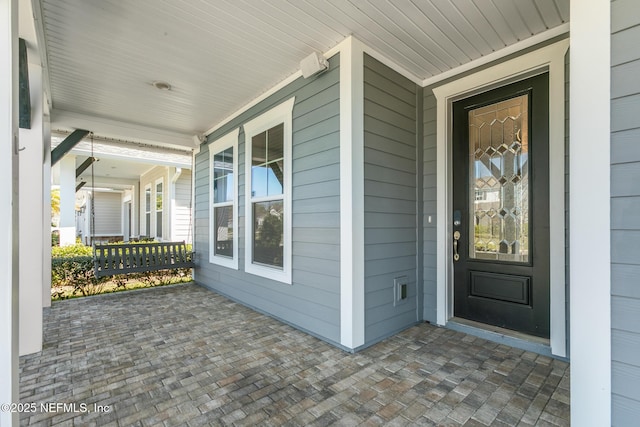 view of exterior entry featuring a porch