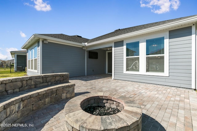 rear view of house featuring fence, an outdoor fire pit, and a patio area