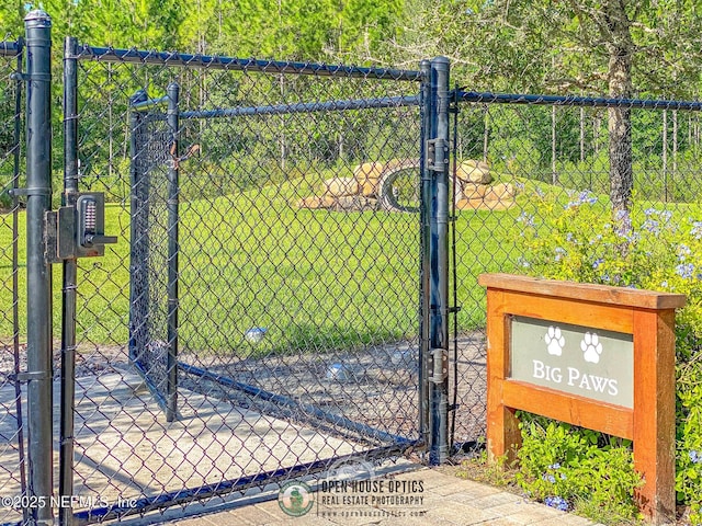 view of gate with fence and a yard