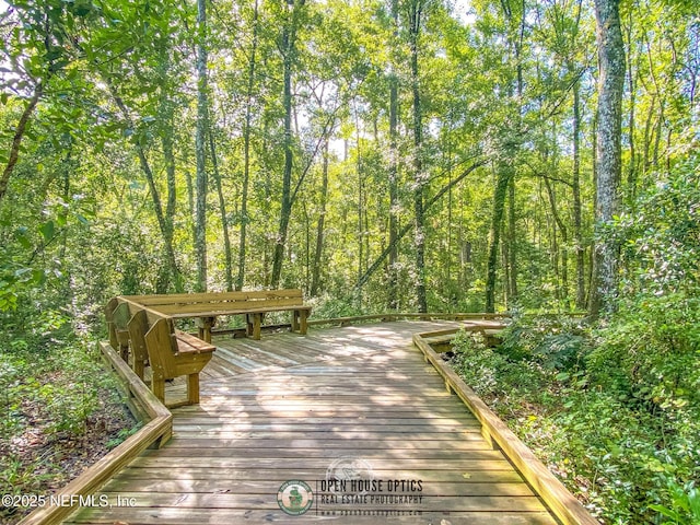 surrounding community with a deck and a forest view