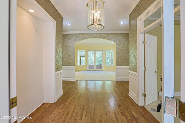 3666 Cypress Point Ct, Green Cove Springs, FL 32043 - corridor featuring ornamental molding, arched walkways, wainscoting, wood finished floors, and a chandelier