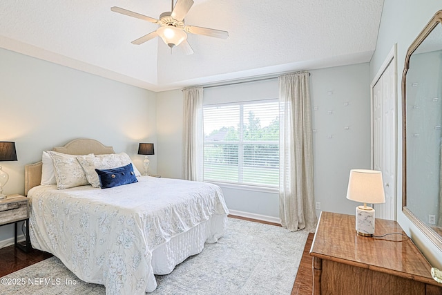 bedroom featuring a textured ceiling, baseboards, a ceiling fan, and wood finished floors