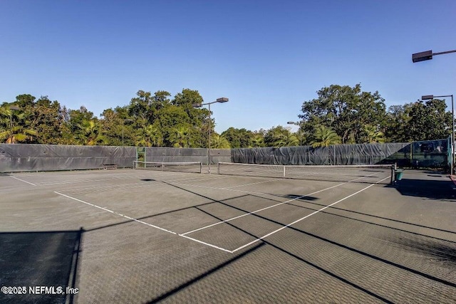 view of tennis court with fence