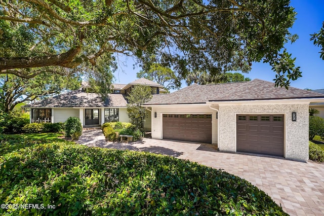 ranch-style home featuring decorative driveway and a garage