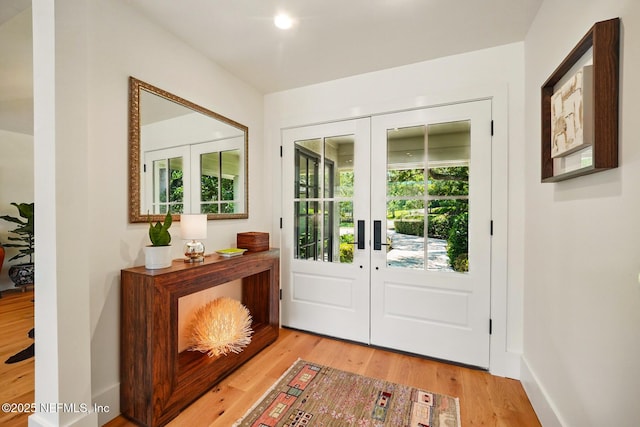 doorway to outside featuring baseboards, french doors, and wood finished floors
