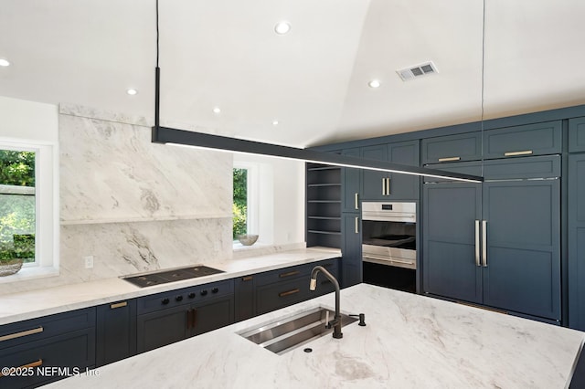 kitchen featuring a sink, decorative backsplash, cooktop, and oven
