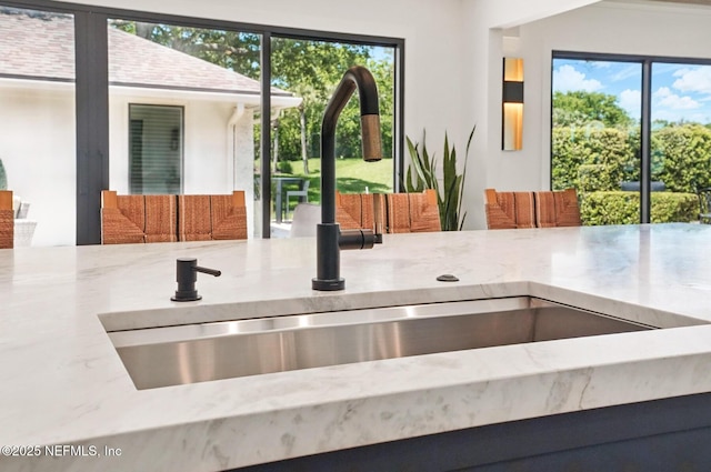 details with light stone countertops and a sink