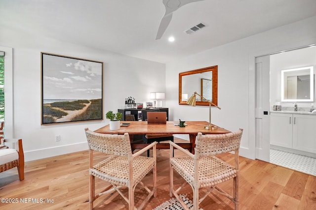 dining room with visible vents, light wood-style flooring, ceiling fan, and baseboards