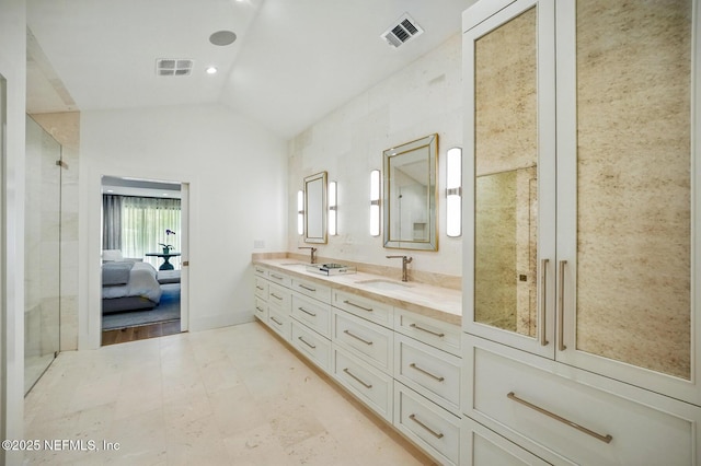 bathroom with visible vents, a sink, vaulted ceiling, and ensuite bath