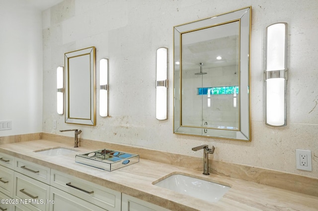 bathroom featuring a sink, a walk in shower, and double vanity