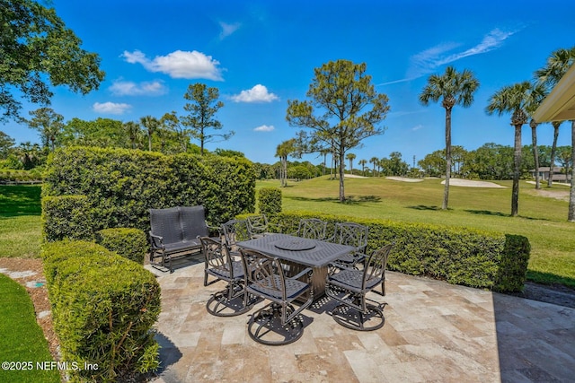 view of patio featuring outdoor dining area and golf course view