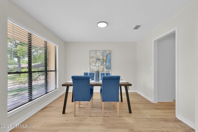 dining room with baseboards, visible vents, and light wood-style floors