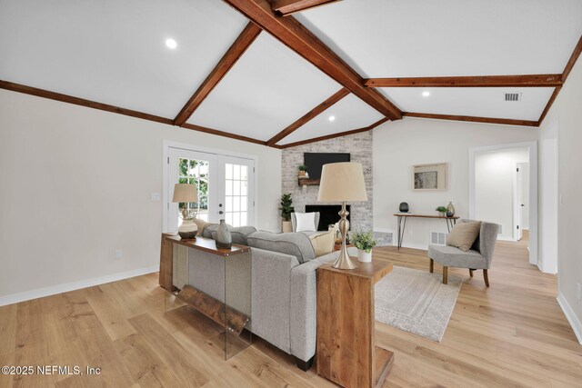 living area featuring lofted ceiling with beams, visible vents, and light wood-style floors