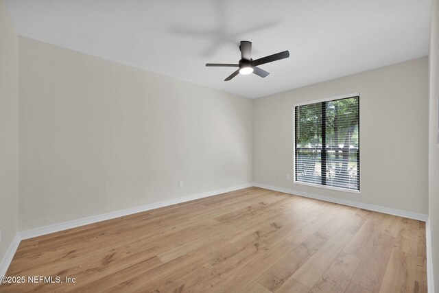 unfurnished room with a ceiling fan, baseboards, and light wood-type flooring