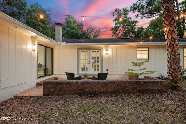entrance to property featuring a patio area, french doors, and a chimney
