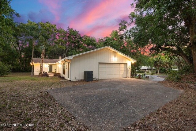 view of side of home with central air condition unit and driveway