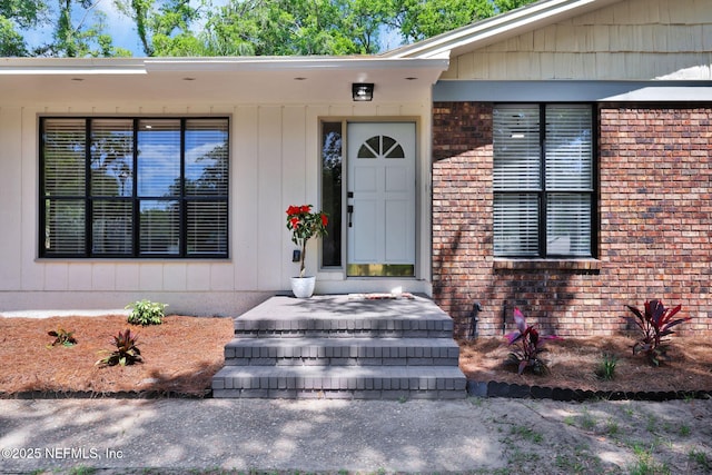 entrance to property featuring brick siding