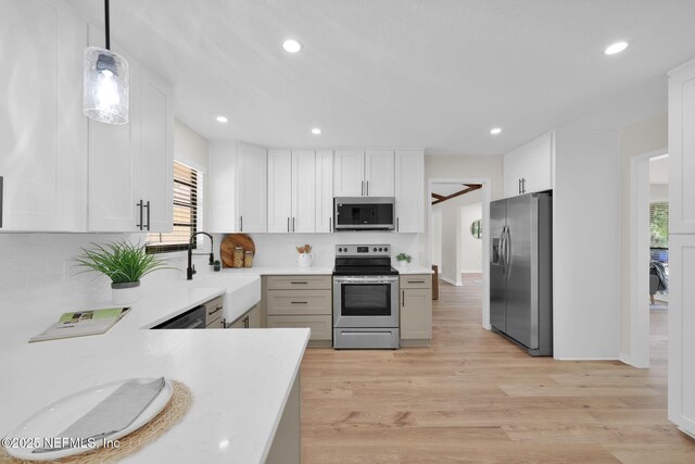 kitchen with a sink, appliances with stainless steel finishes, a healthy amount of sunlight, and tasteful backsplash