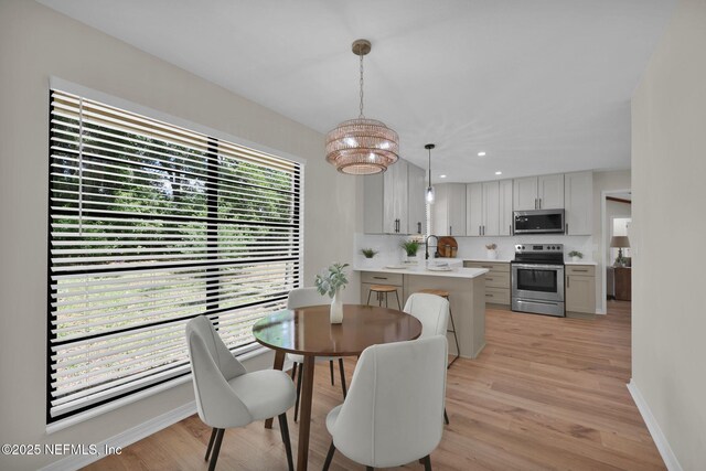 dining room with light wood-style floors, baseboards, recessed lighting, and a chandelier