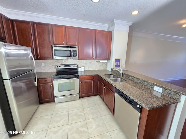kitchen with ornamental molding, a peninsula, reddish brown cabinets, a sink, and appliances with stainless steel finishes