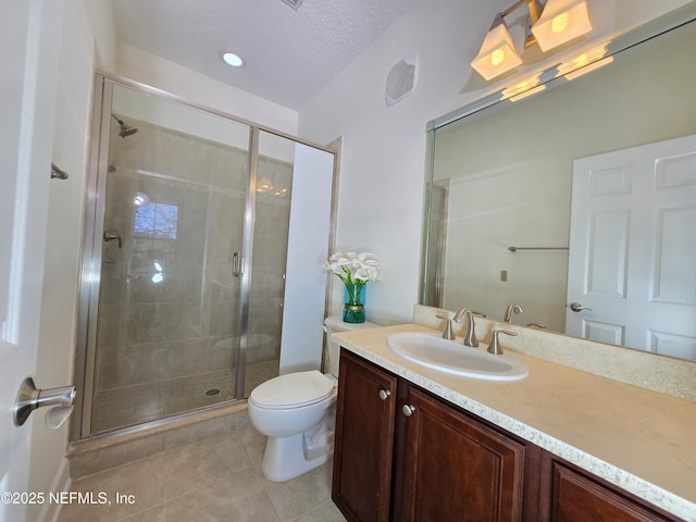 bathroom with a textured ceiling, tile patterned flooring, a stall shower, vanity, and toilet